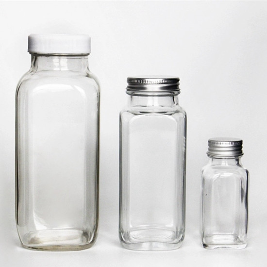 Botellas de jugo de vidrio cuadrado con tapa.