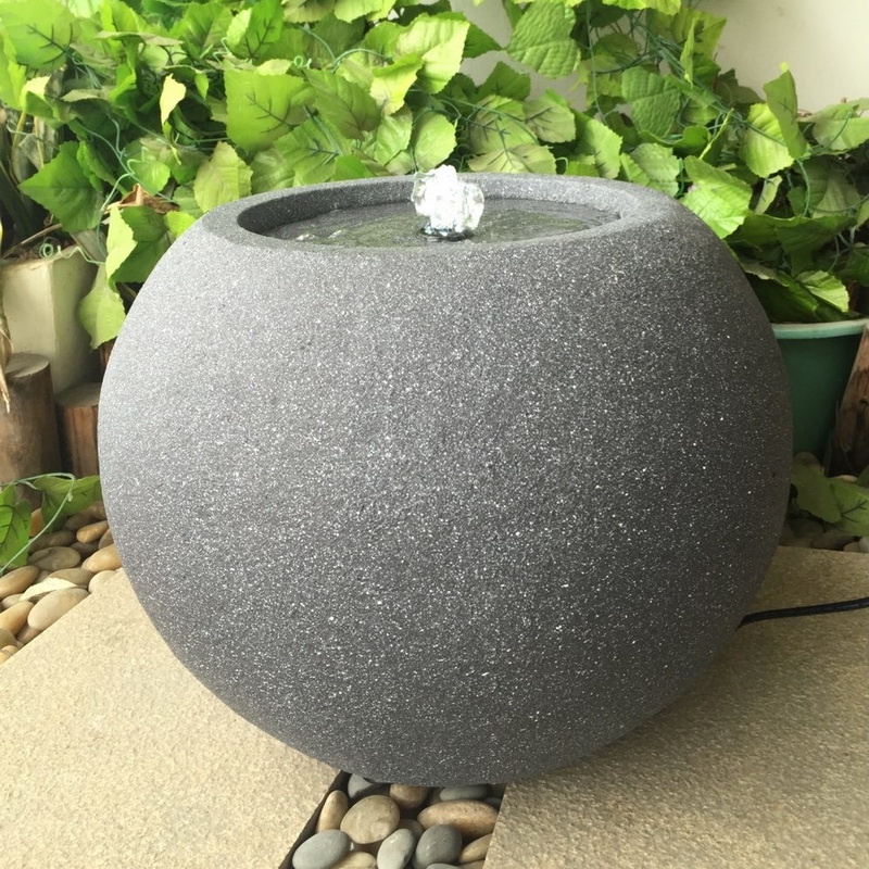 Fuente de agua circular en superficie de piedra para decoración de jardín.